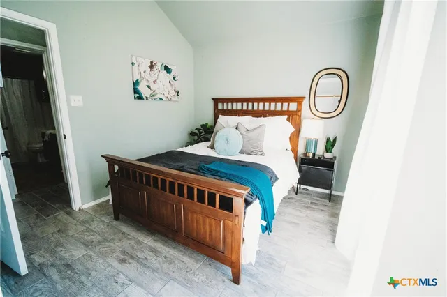 a bedroom with a bed and a mirror on dresser