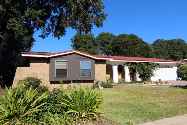 a kitchen with granite countertop wooden cabinets a stove top oven a sink and dishwasher