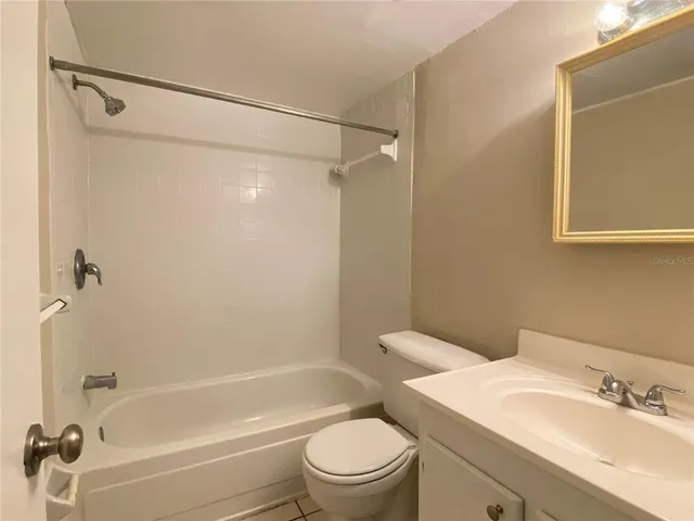 a bathroom with a bathtub shower sink vanity and toilet
