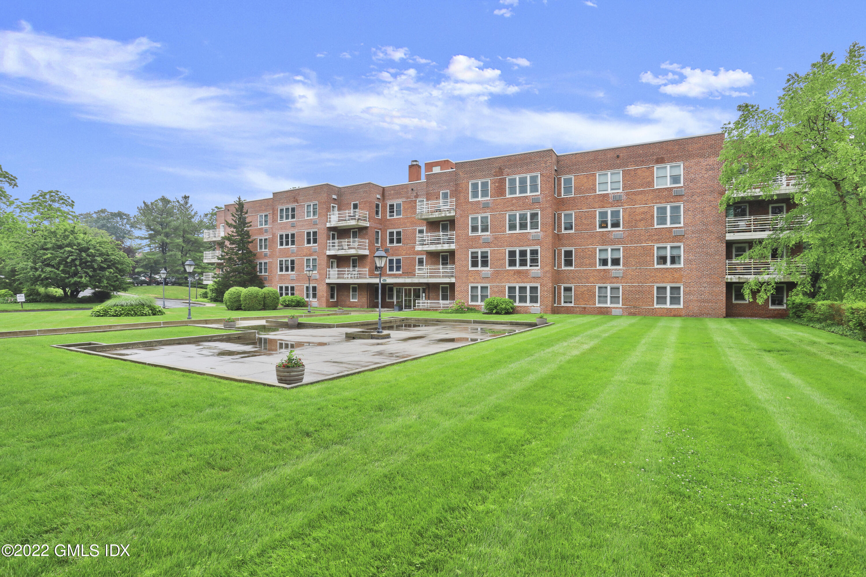 52 Lafayette Place, Unit 2H Greenwich, CT 06830 - Photo 10 of 11 a view of a big room with a big yard and large trees