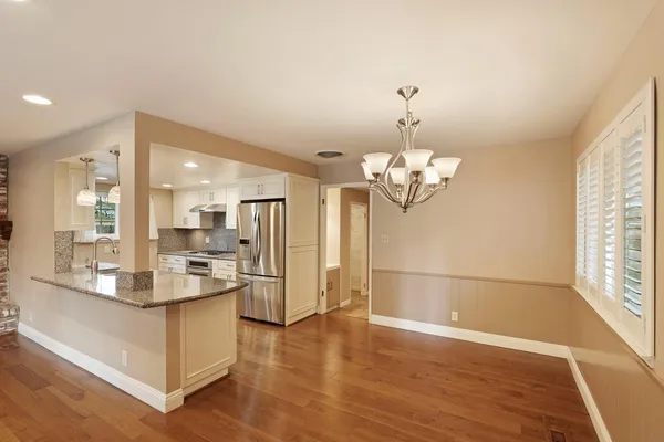 a view of a kitchen with granite countertop cabinets a counter and stainless steel appliances