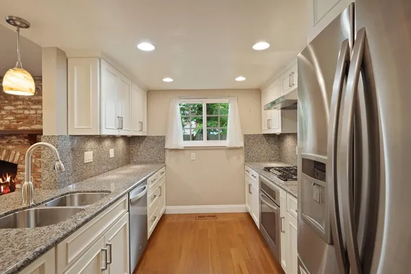 a kitchen with stainless steel appliances granite countertop a refrigerator sink and cabinets