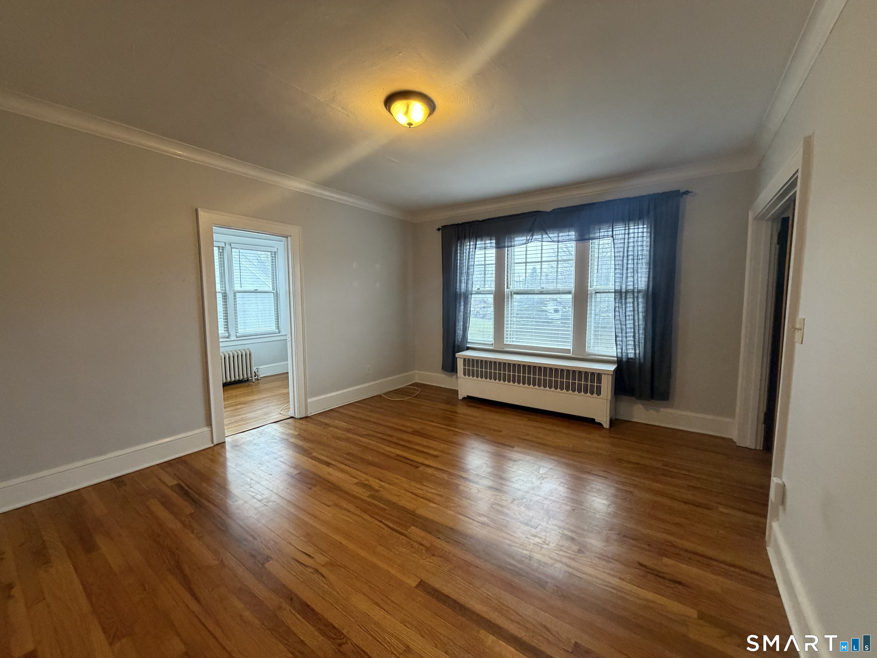 65 Burr Street West Hartford, CT 06107 - Photo 2 of 11 an empty room with wooden floor and windows