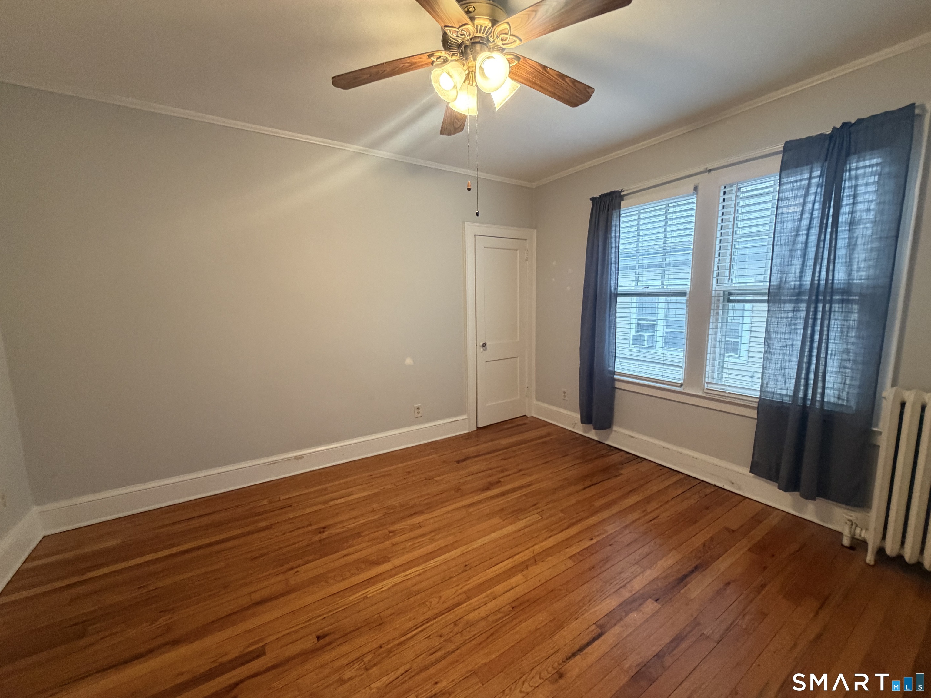 65 Burr Street West Hartford, CT 06107 - Photo 7 of 11 a view of an empty room with window and wooden floor