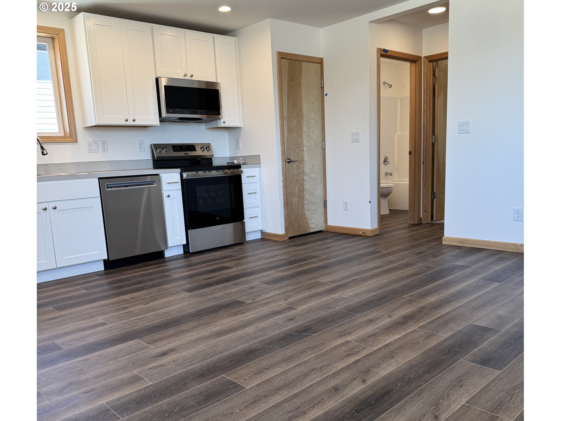 723 ST Charles Street Eugene, OR 97402 - Photo 4 of 30 a kitchen with wooden floors and black appliances