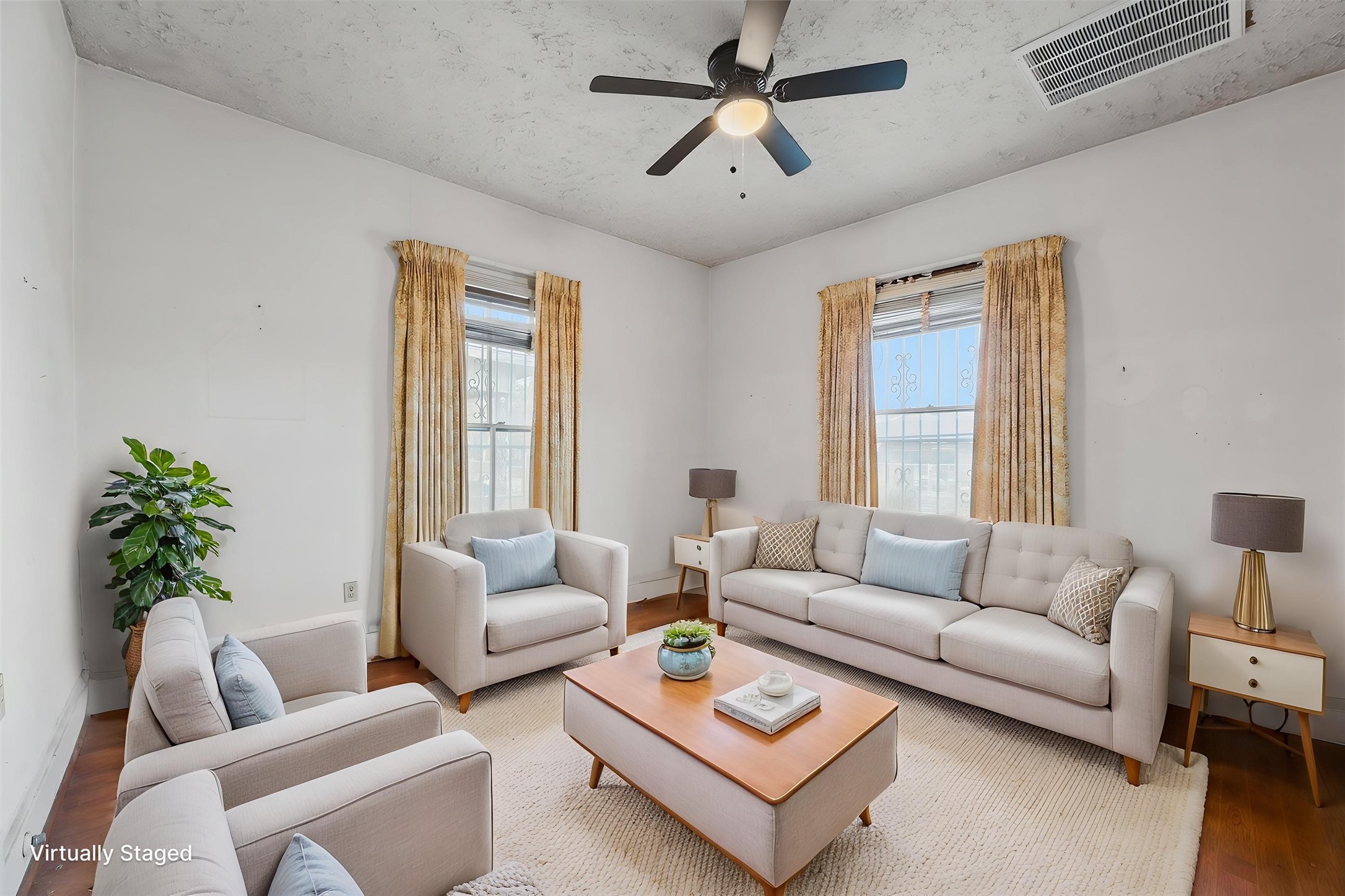 Bright and inviting living room with large windows, neutral walls, and hardwood flooring. Perfect for relaxation and entertaining.