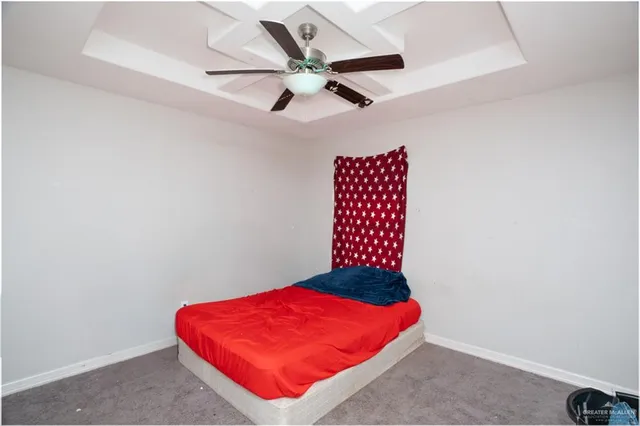 an empty room with red walls and ceiling fan