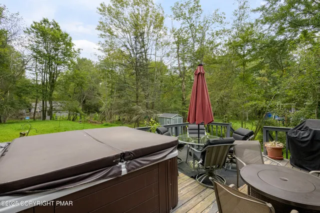 a view of a patio with a table chairs and a barbeque
