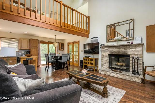 a living room with furniture a fireplace a flat screen tv and couches