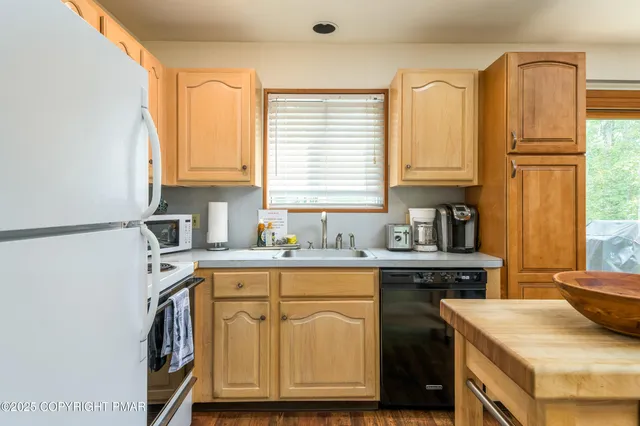 a front view of a house with a garden and trees