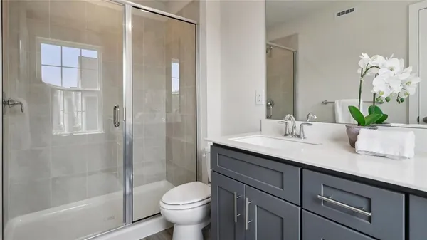 a bathroom with a granite countertop sink toilet and shower