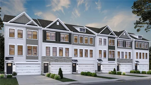 a front view of a residential apartment building with a yard and garage