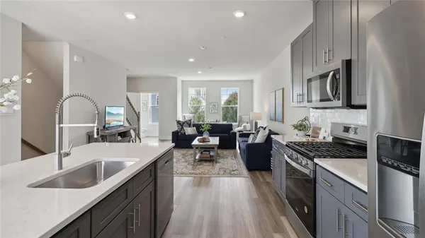 a large kitchen with stainless steel appliances granite countertop a lot of counter space and wooden floors