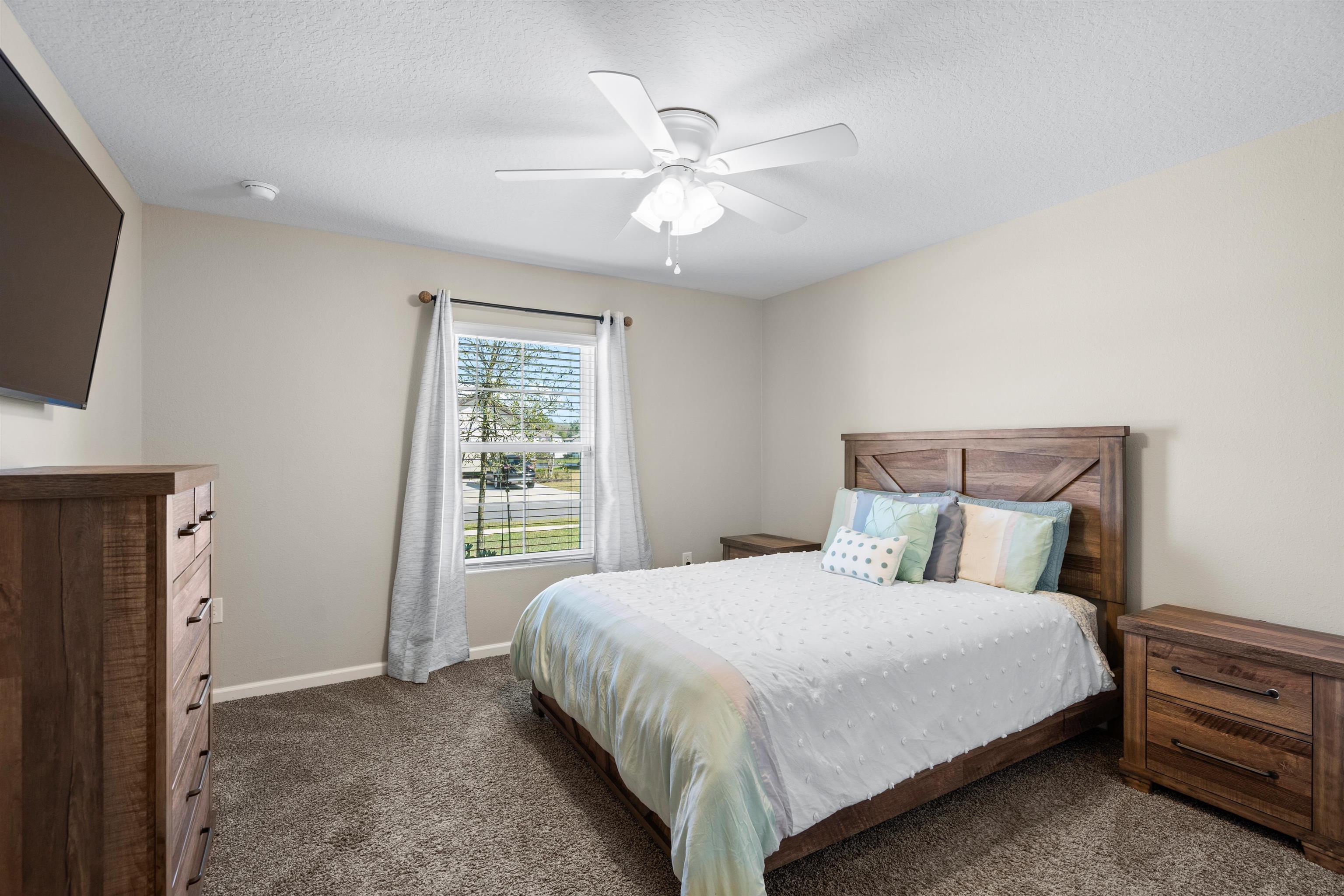 408 Falcon Ridge Road St. Augustine, FL 32084 - Photo 19 of 26 a bedroom with a large bed and a chandelier