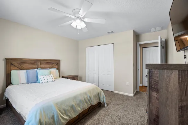 a bedroom with a large bed and a chandelier