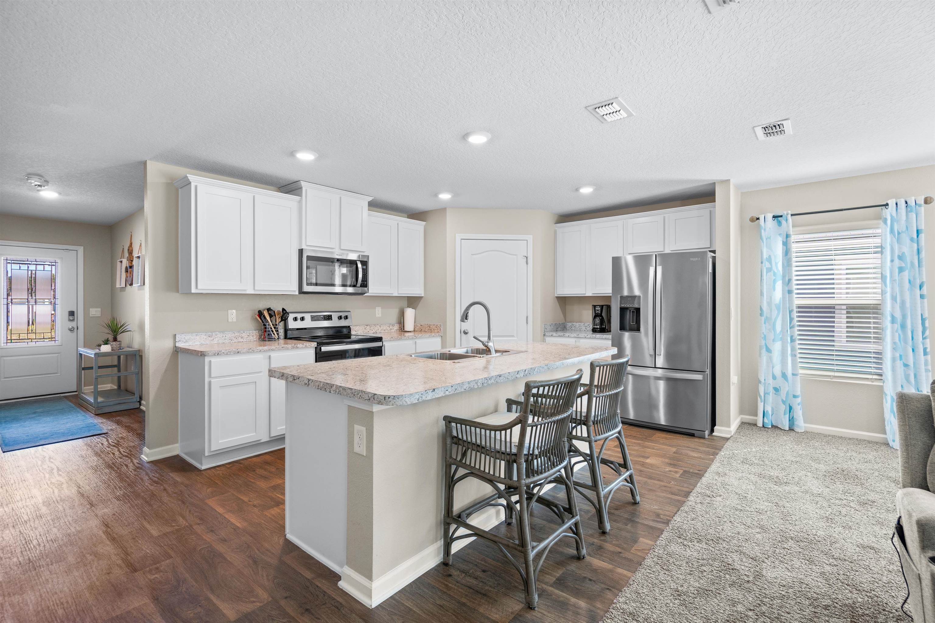408 Falcon Ridge Road St. Augustine, FL 32084 - Photo 6 of 26 a kitchen with white cabinets and stainless steel appliances
