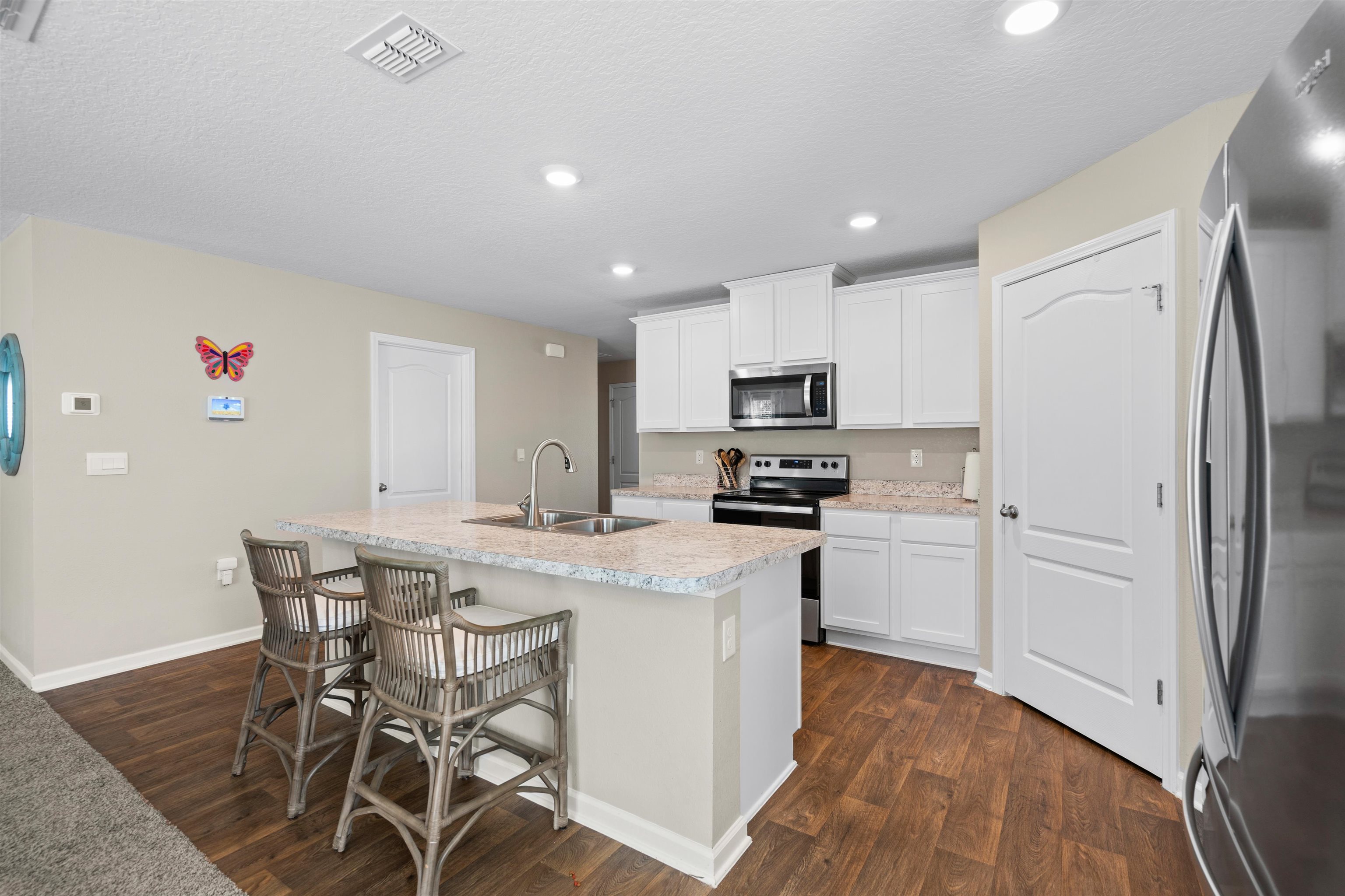 408 Falcon Ridge Road St. Augustine, FL 32084 - Photo 7 of 26 a kitchen with stainless steel appliances a white table chairs refrigerator and sink