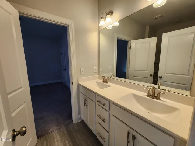 a bathroom with a double vanity sink and a mirror