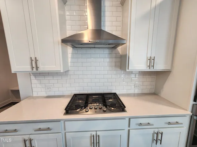 a stove top oven sitting inside of a kitchen