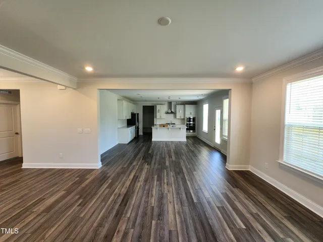 a view of a big room with wooden floor and windows