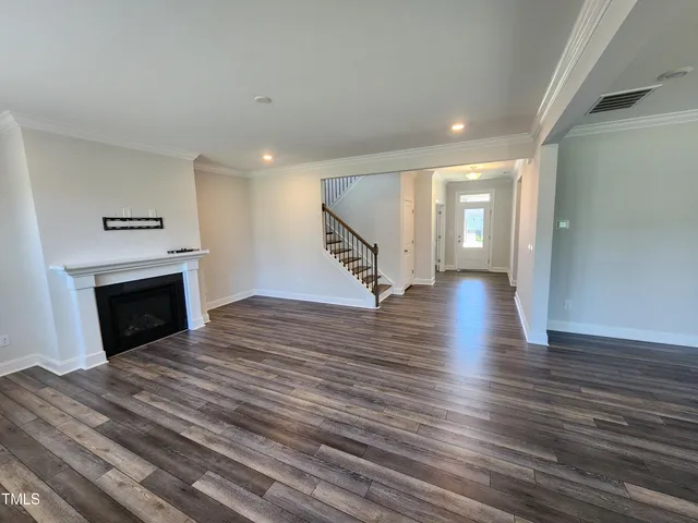 a view of a hallway with wooden floor and a fireplace
