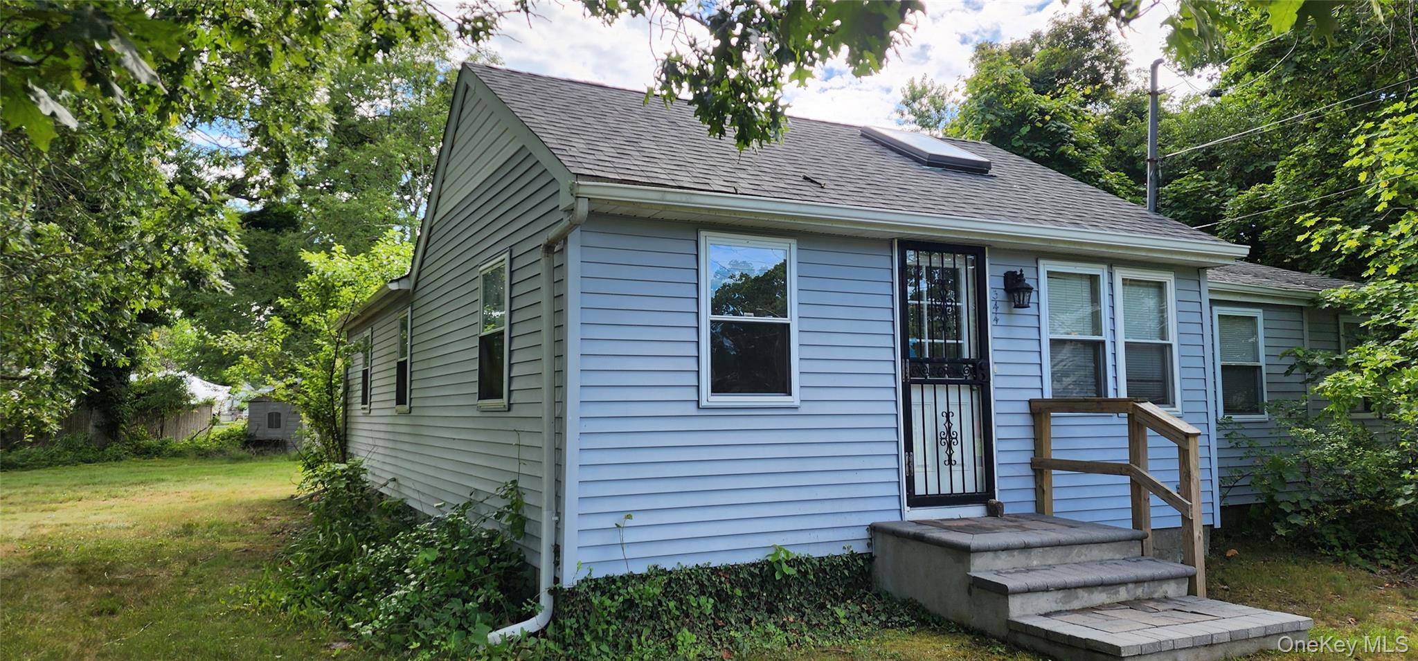 Bungalow-style home with roof with shingles and a front lawn