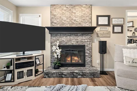 a living room with furniture a flat screen tv and a fireplace