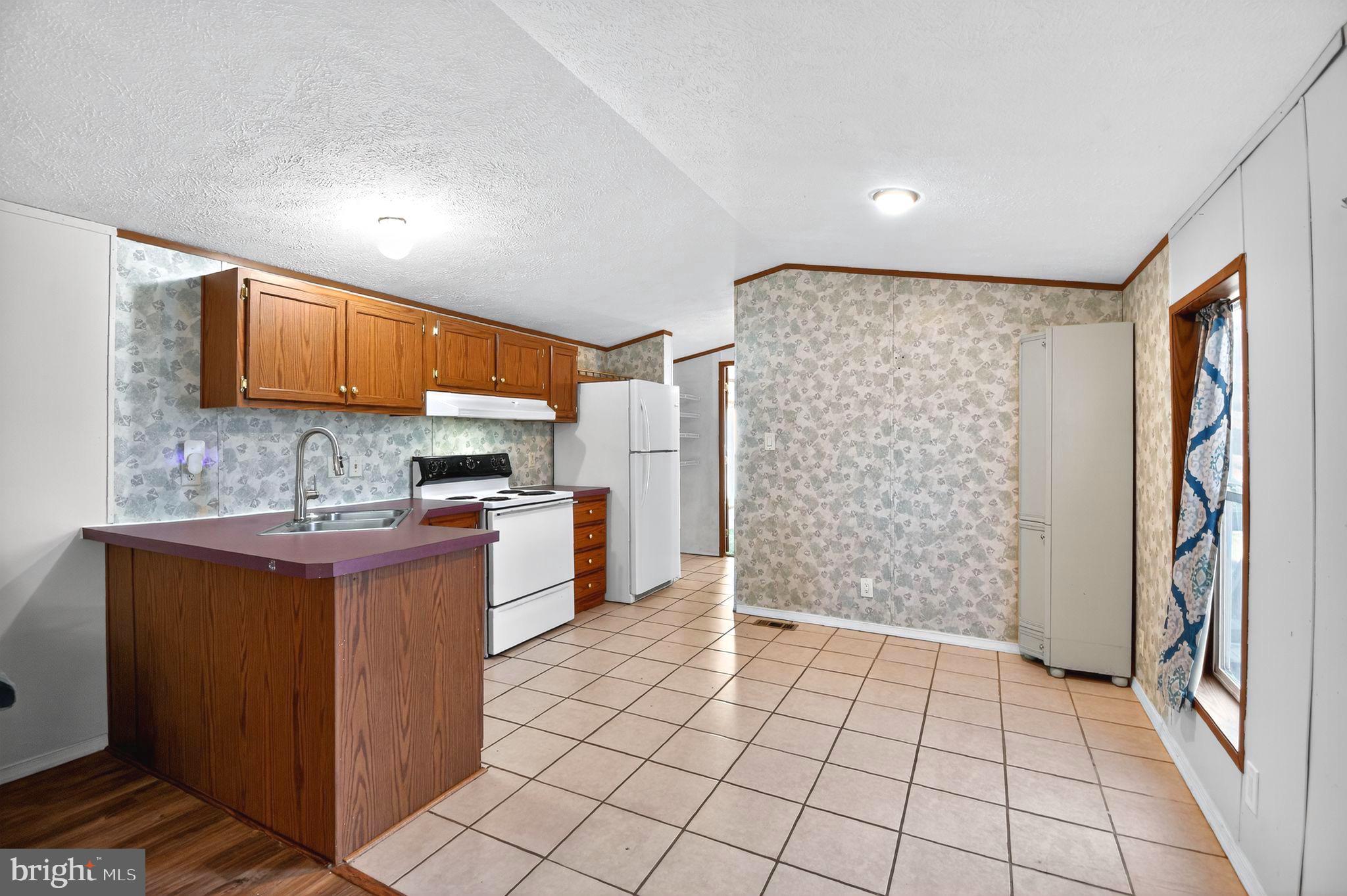 263 Konrad Morgan Way Lothian, MD 20711 - Photo 4 of 18 a kitchen with stainless steel appliances granite countertop a refrigerator and a stove top oven