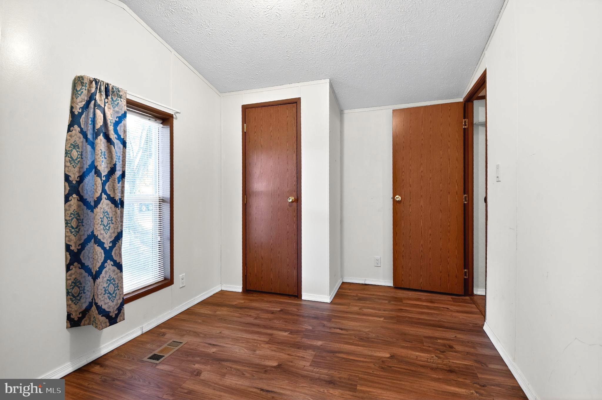 263 Konrad Morgan Way Lothian, MD 20711 - Photo 7 of 18 an empty room with wooden floor and closet