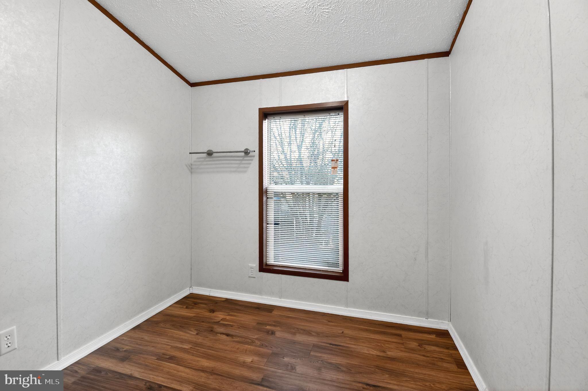 263 Konrad Morgan Way Lothian, MD 20711 - Photo 8 of 18 a view of an empty room with wooden floor and a window