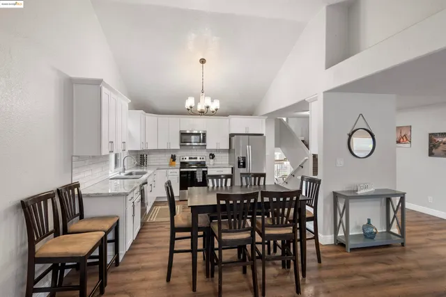 a view of a dining room with furniture a chandelier and wooden floor