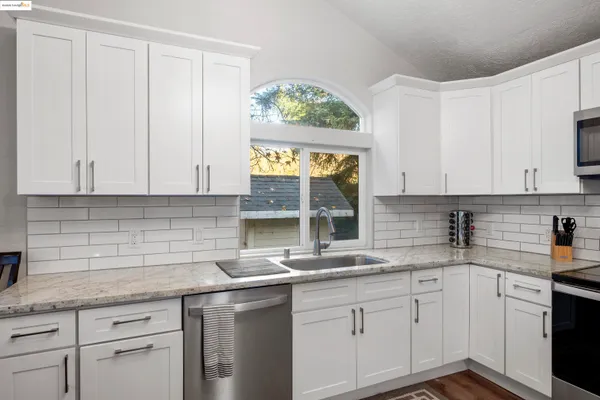 a kitchen with stainless steel appliances granite countertop white cabinets and a granite counter tops