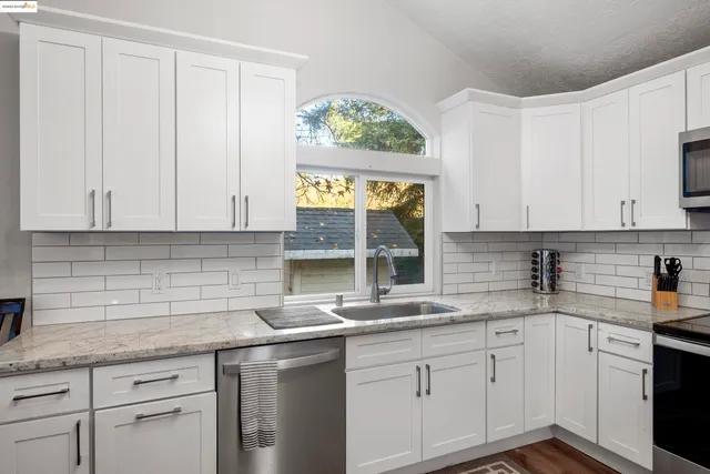 a kitchen with stainless steel appliances granite countertop white cabinets and a granite counter tops