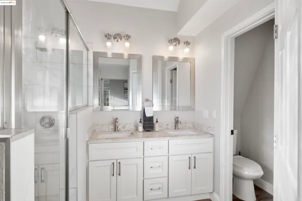 a bathroom with a granite countertop sink a toilet and a mirror