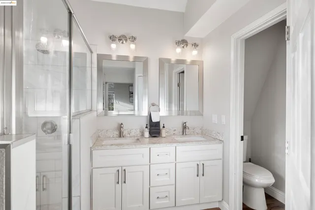 a bathroom with a granite countertop sink a toilet and a mirror