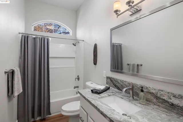 a bathroom with a granite countertop sink toilet and shower