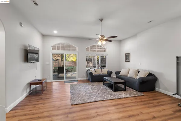 a living room with furniture a chandelier and a flat screen tv