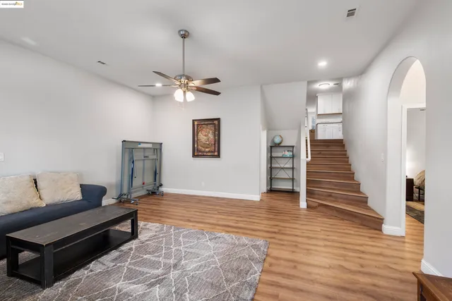 a living room with furniture and a wooden floor