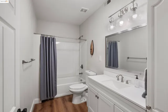 a bathroom with a sink a toilet and shower a mirror