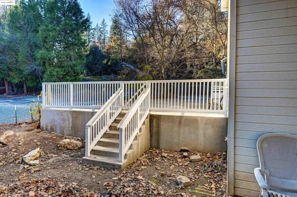 a view of a deck with a chair and white fence
