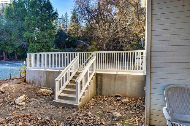 a view of a deck with a chair and white fence