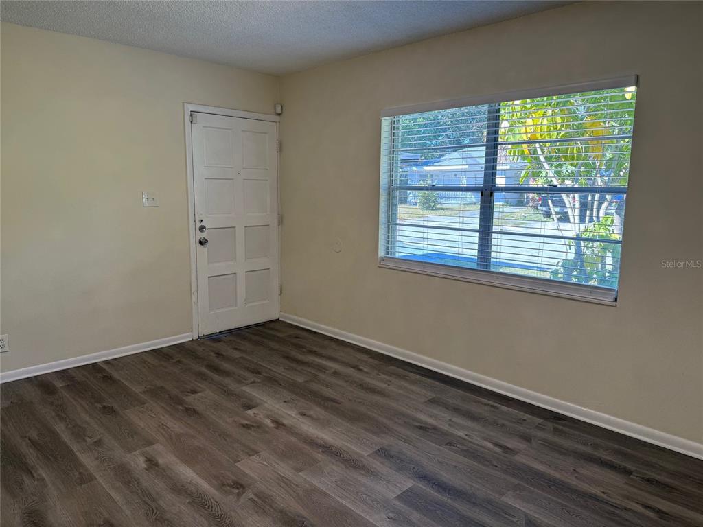 1740 West Walnut Street Tampa, FL 33607 - Photo 3 of 21 a view of an empty room with wooden floor and a window