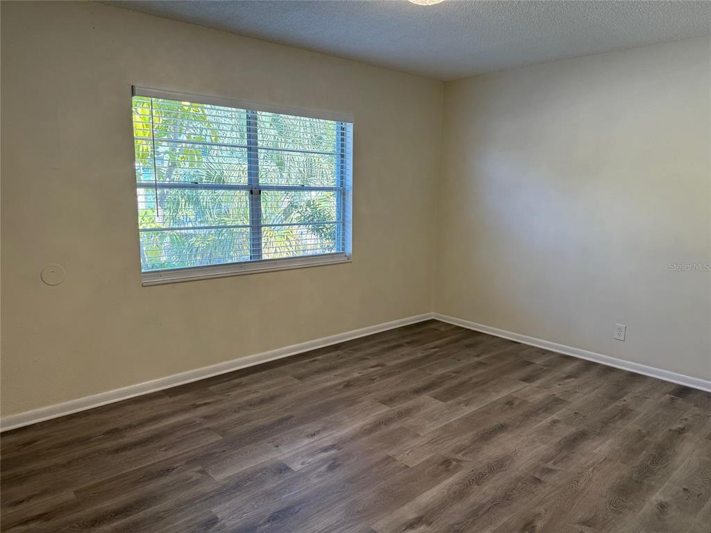 1740 West Walnut Street Tampa, FL 33607 - Photo 4 of 21 an empty room with wooden floor and windows