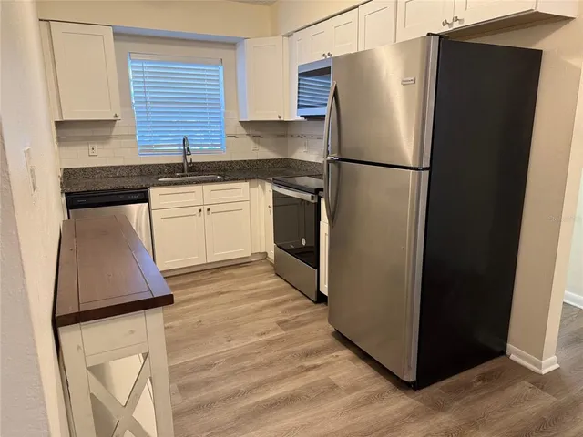 a kitchen with stainless steel appliances a refrigerator sink and cabinets
