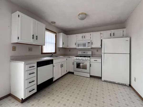 a kitchen with cabinets stainless steel appliances and sink