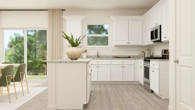 a kitchen with a white stove top oven and white cabinets with wooden floor