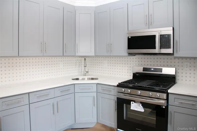 a kitchen with white cabinets and black appliances