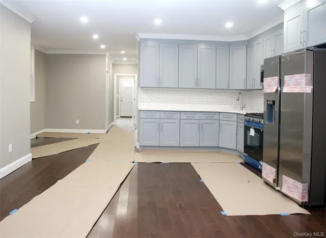 a kitchen with a sink a refrigerator and cabinets