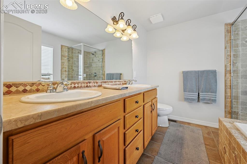 3430 Double Tree Court Colorado Springs, CO 80921 - Photo 32 of 50 a bathroom with a sink a vanity a mirror and a bathtub