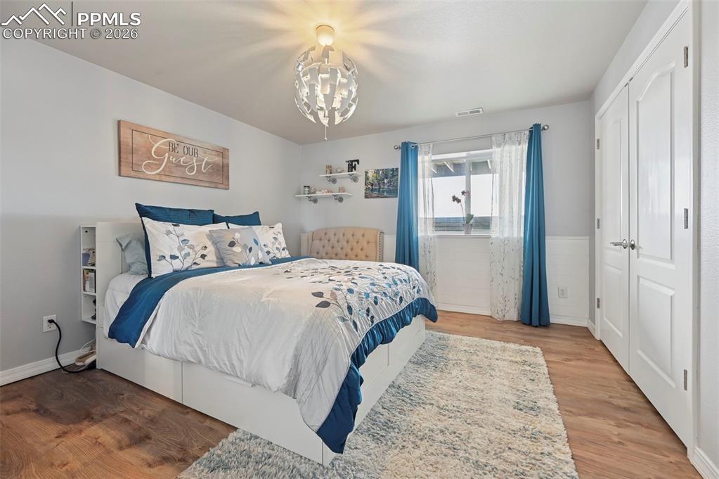 3430 Double Tree Court Colorado Springs, CO 80921 - Photo 43 of 50 a bedroom with a large bed and a chandelier